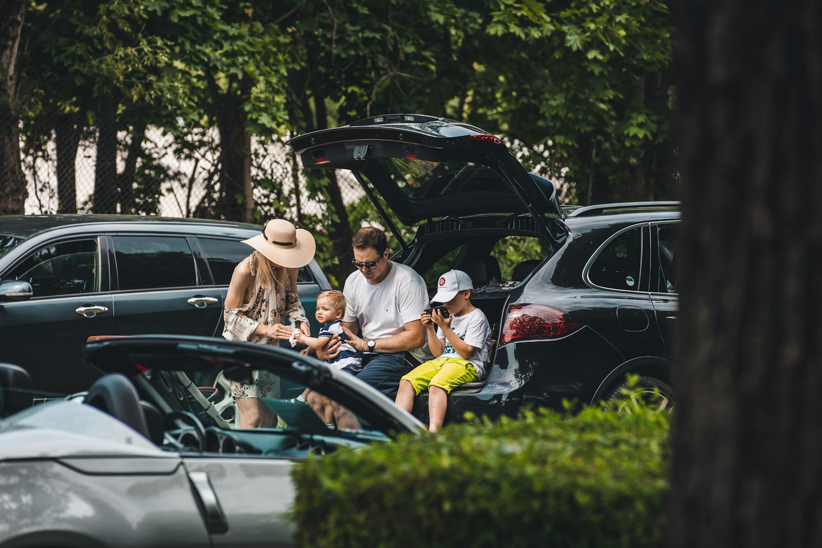 A family sitting together in the open boot of their SUV